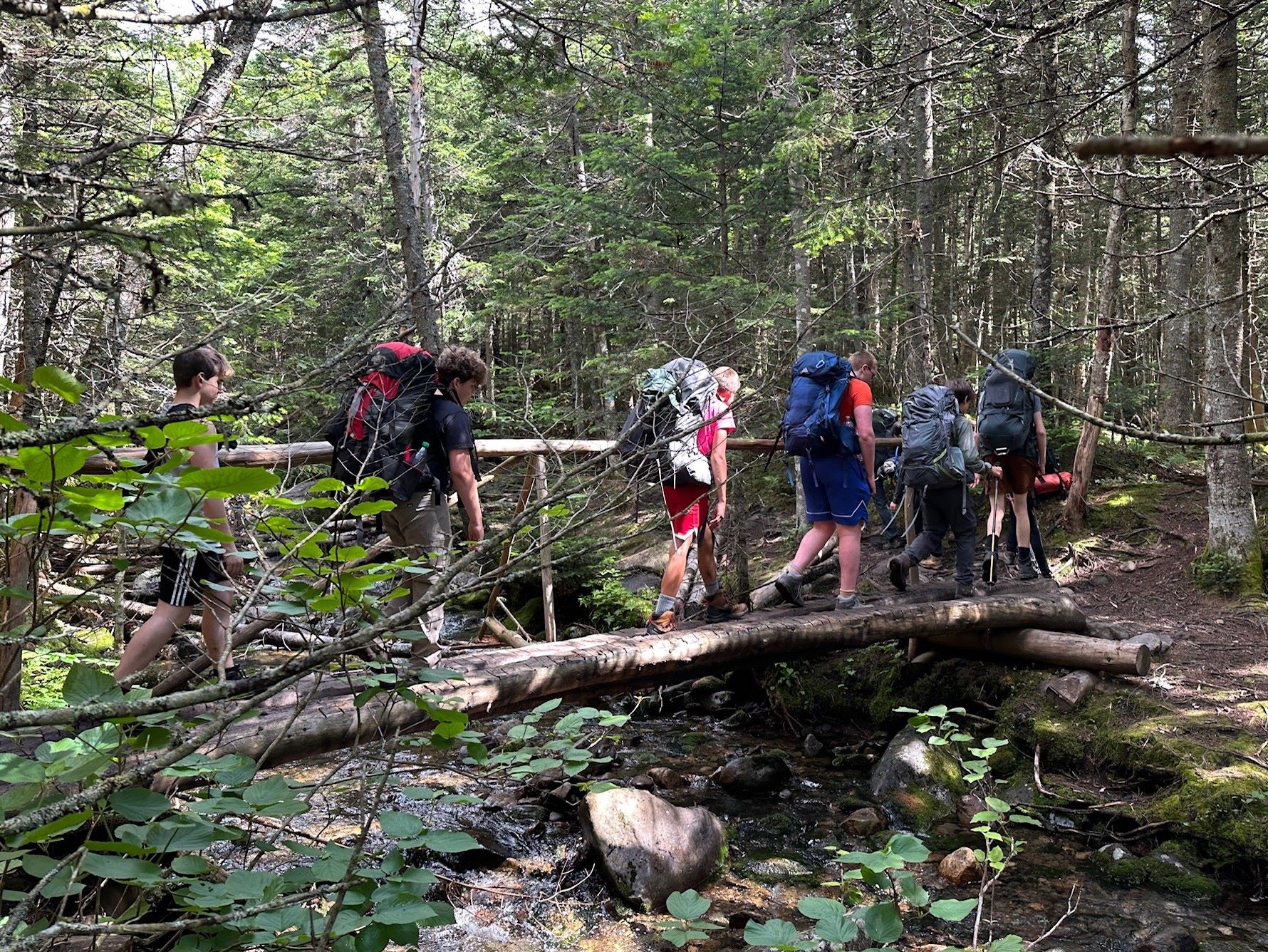 Scouts crossing a bridge over a river